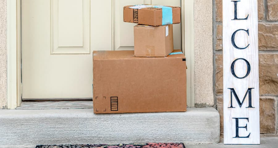 Packages on the doorstep of a home with a welcome sign in Des Moines